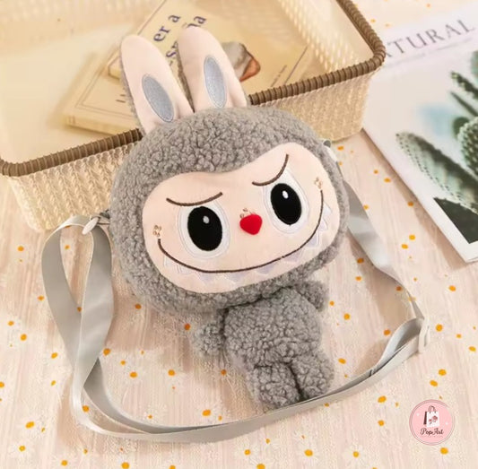Sac peluche gris Labubu posé sur fond blanc, au design mignon et espiègle.